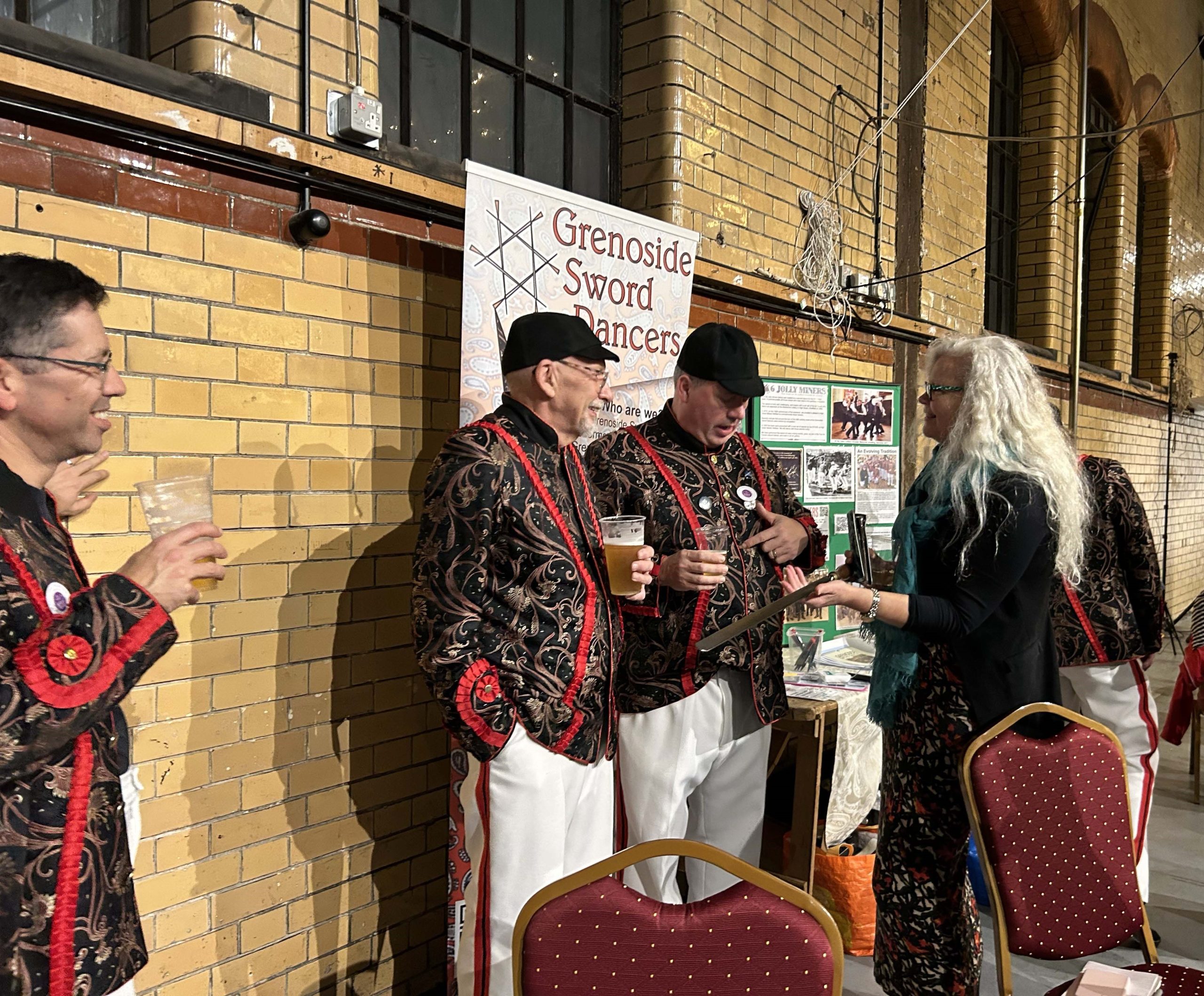 Cradle of Fire PR Emma Boden talking to members of the Grenoside Sword Dancers, including a 5th generation participant, Kelham Island Museum © Eileen Haring Woods