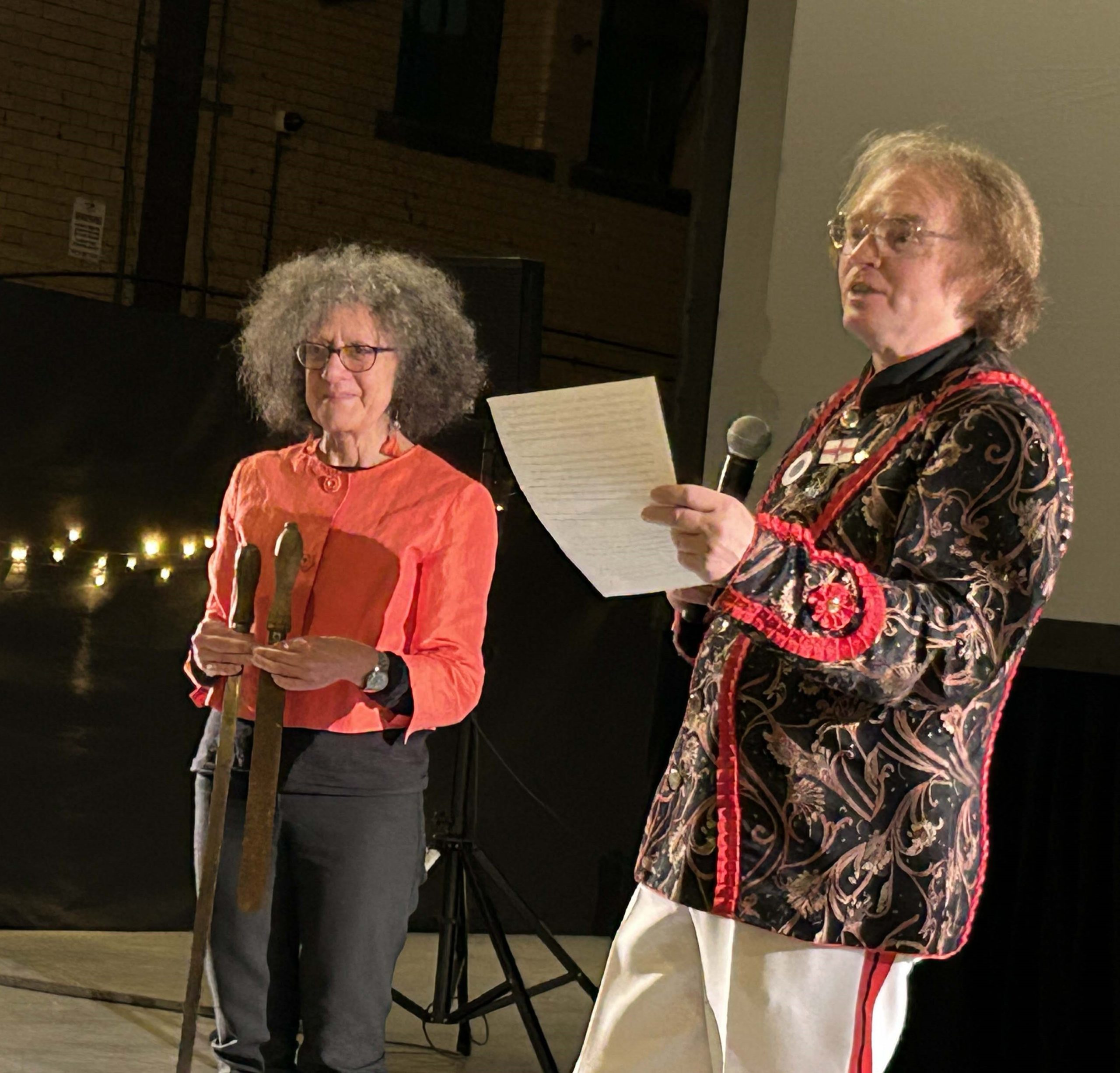 Cradle of Fire's Diana Scarborough holding swords while Grenoside leader Ashley prepares to teach some of the attendees at the film premiere how to perform the dance, Kelham Island Museum, 2024 © Eileen Haring Woods