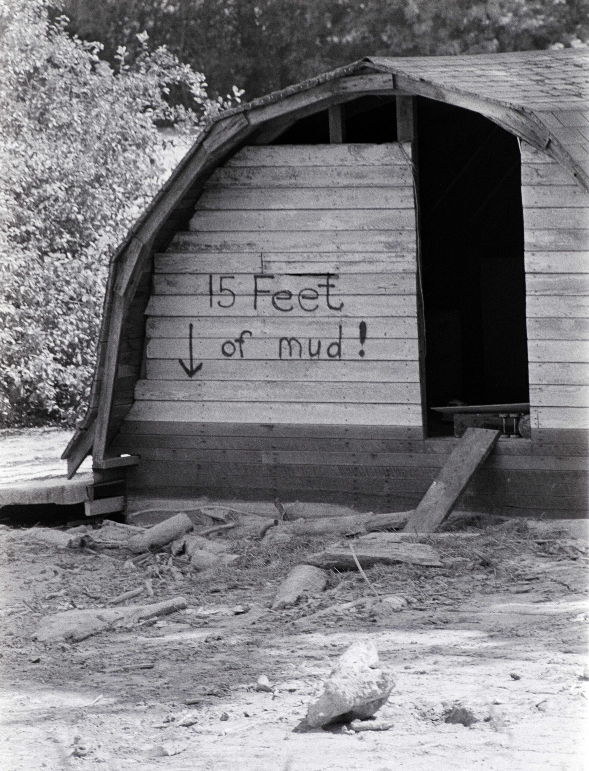A wooden hut with the words 15 feet of mud painted on it.